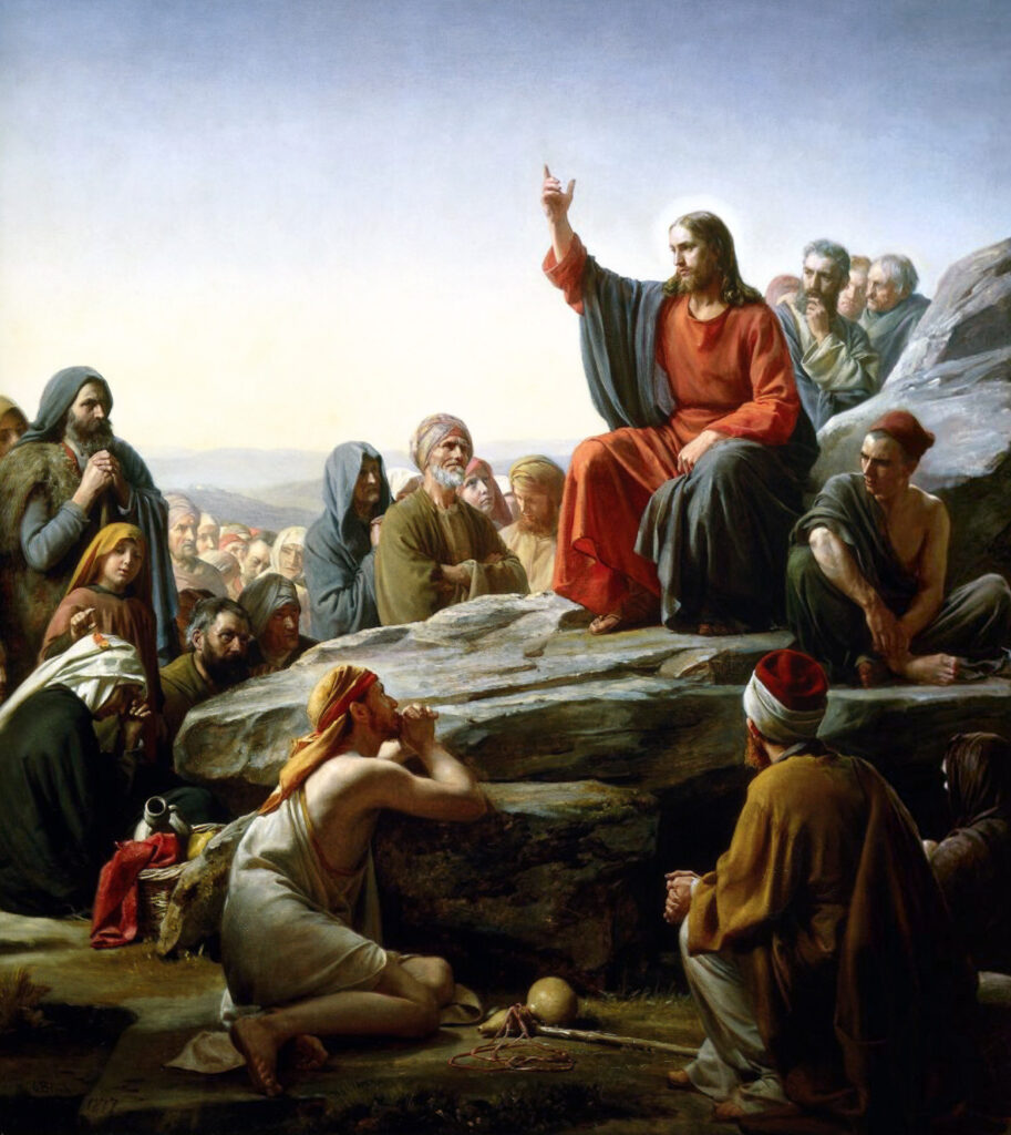 Painting The Sermon on the Mount by
Carl Bloch. Jesus sits on a rock, preaching with his right arm in the air. A crowd of followers surrounds him.